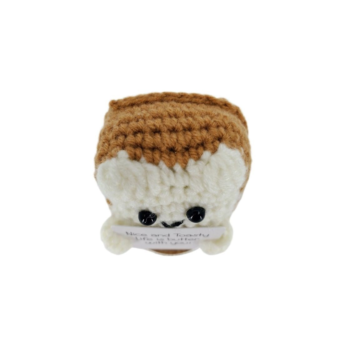 Crocheted bread plush toy with a white base and brown top on a white background