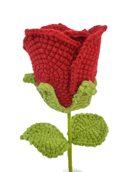 A single red crochet rose with green leaves, crafted from yarn, depicted against a white background