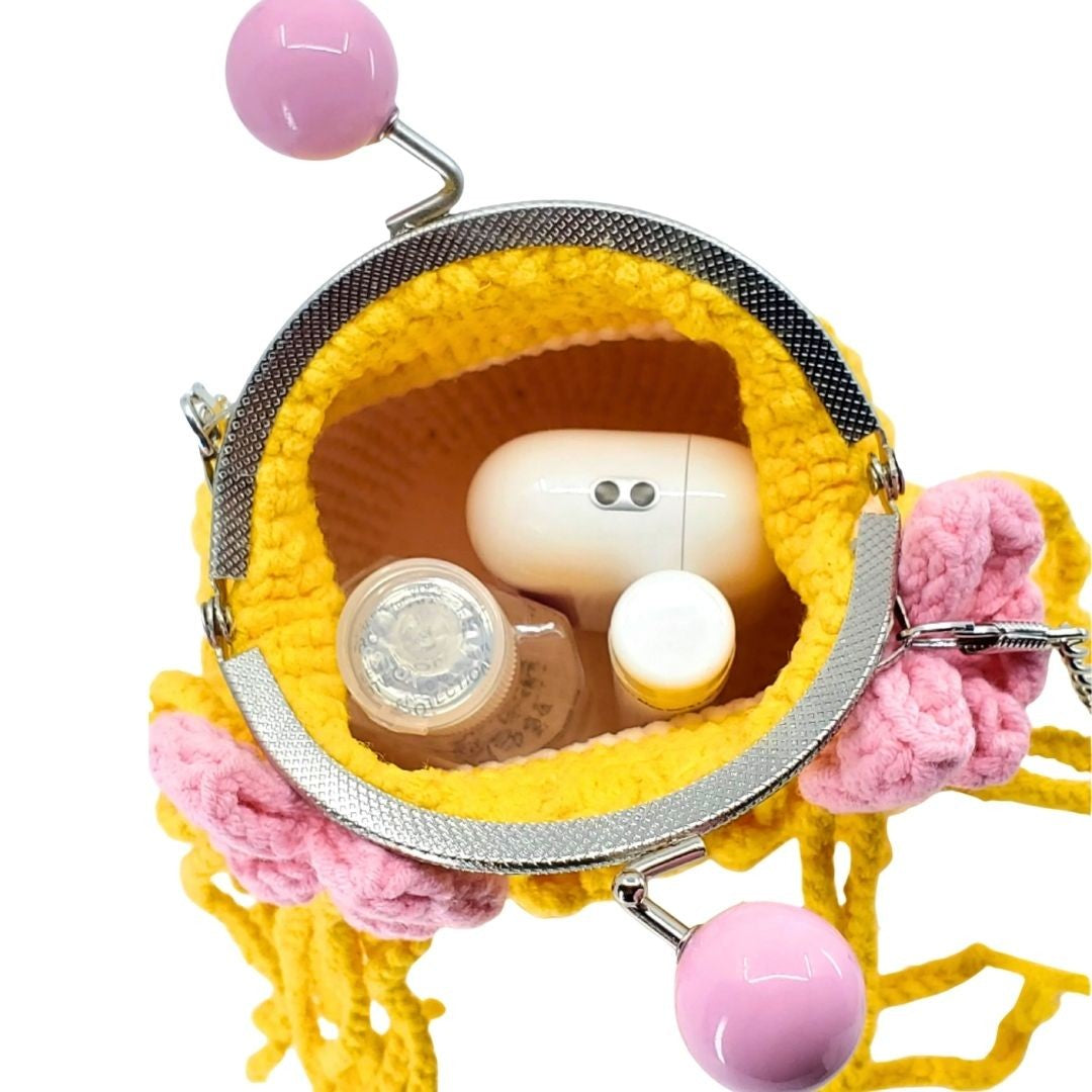 Yellow and pink handbag with a white square object inside on a white background