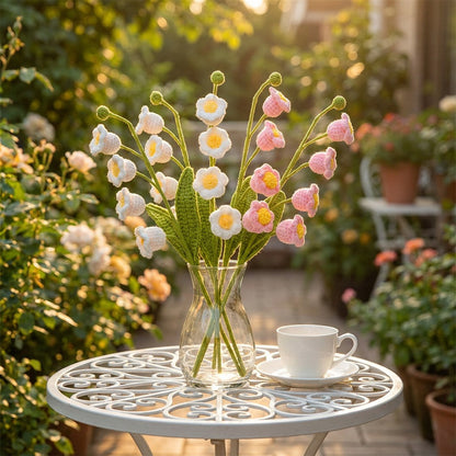 Bouquet of flowers in a vase on a table with a cup and saucer in a garden setting
