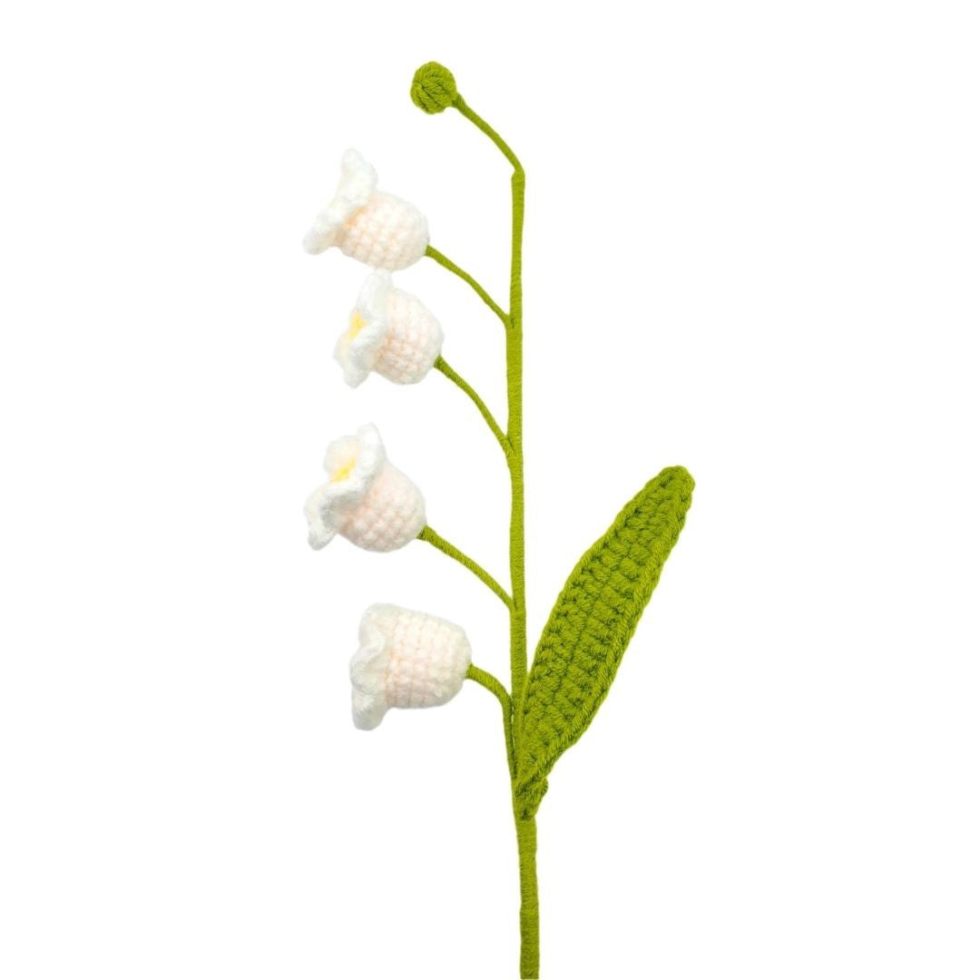 Crocheted flower with white petals and green stem on a white background