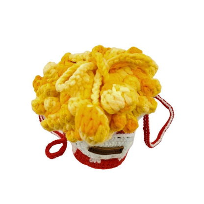 Crocheted yellow popcorn on a red bucket designed bag on a white background