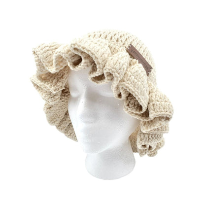 Beige crocheted ruffled brim bucket hat on a mannequin head against a white background