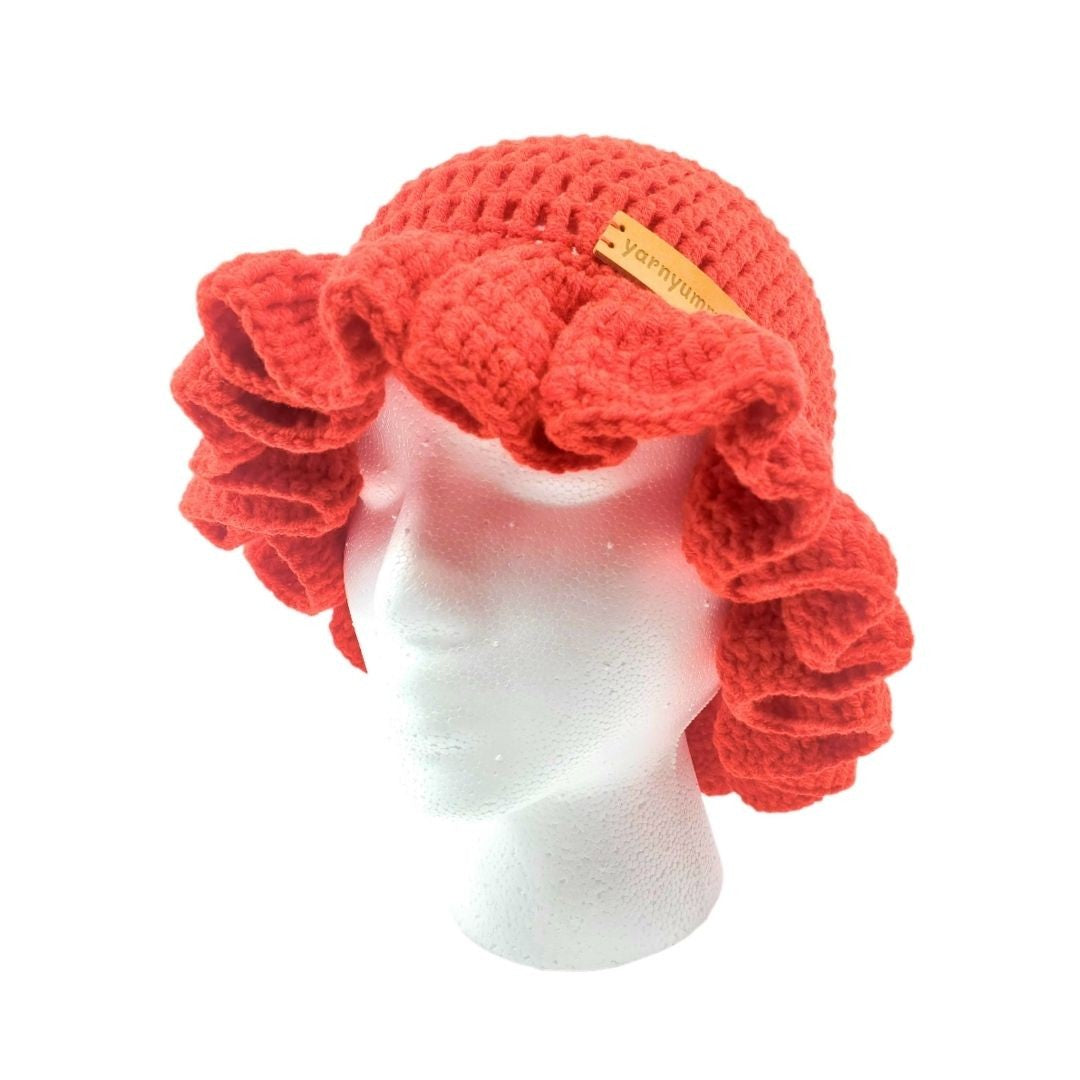 Red crocheted ruffled brim bucket hat on a mannequin head with a white background