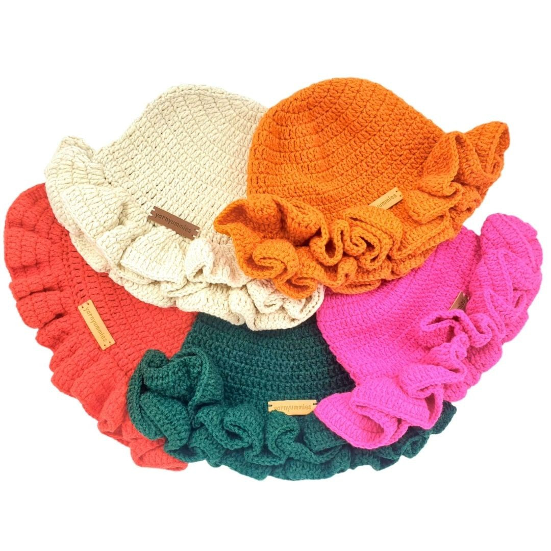 Set of colorful crochet hats with ruffled edges on a white background