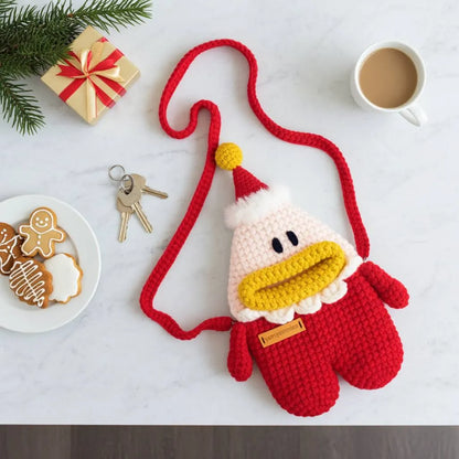 Crocheted Santa designed  bag on a table with cookies, coffee, and gift box.