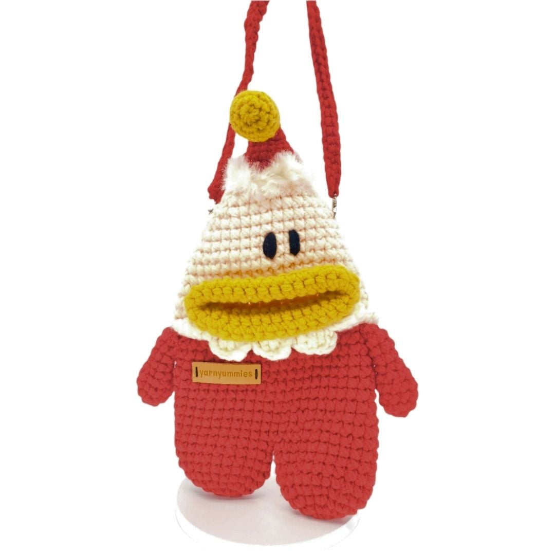 Crocheted santa character with a red outfit and white hat bag on a white background
