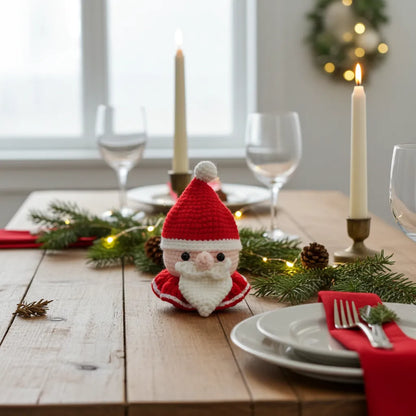 Christmas-themed table setting with a small Santa Claus figurine, candles, and greenery.