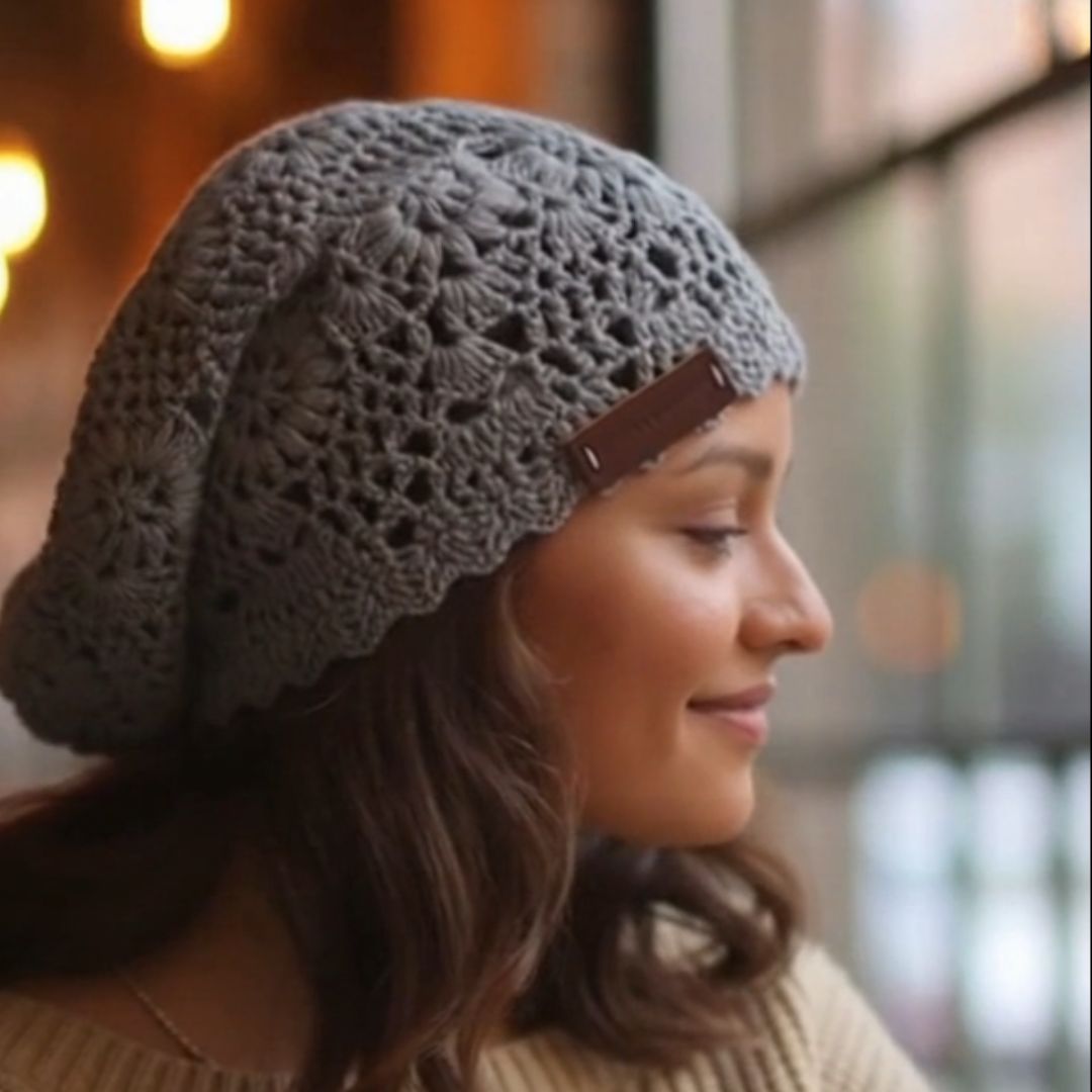 Woman wearing a gray knit beanie with a leather strap in an outdoor setting