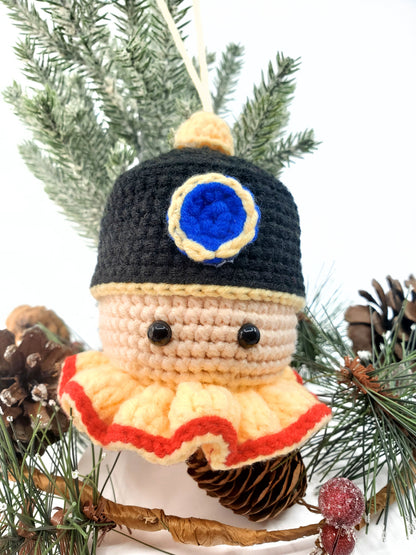Handmade Nutcracker Head decoration with milk cotton yarn, featuring plastic eyes, black hat with a blue circle, beige face with red lips, and orange chin strap.