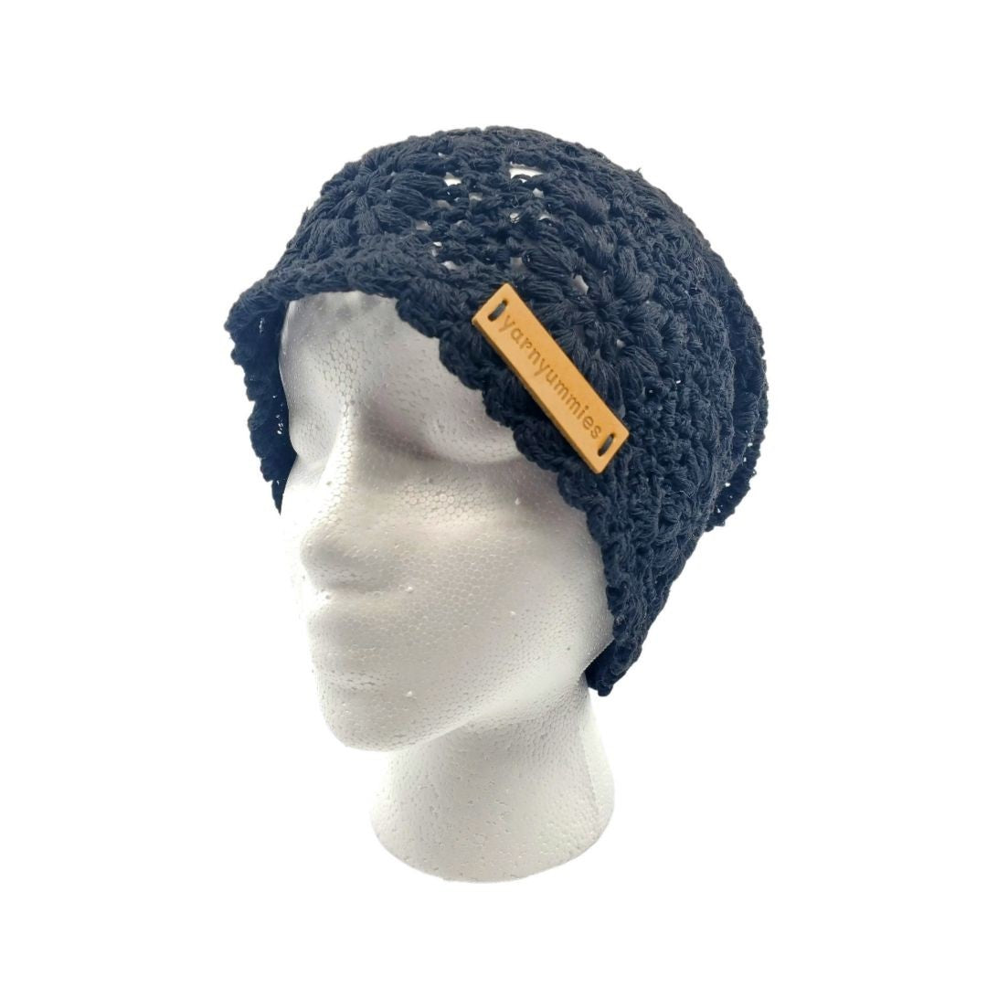 Black knitted hat on a mannequin head with a visible brand tag against a white background