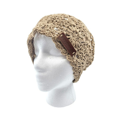 Beige crochet hat with brown leather strap on a mannequin head against a white background