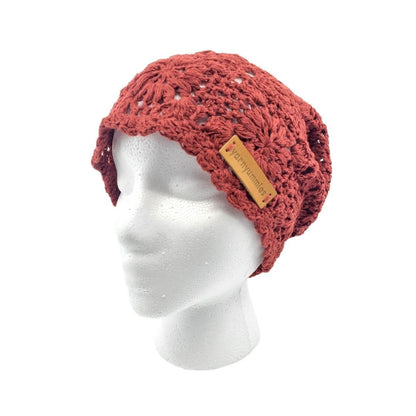Red knitted beanie on a mannequin head with a visible brand label against a white background