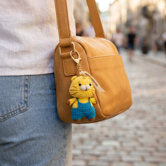 Yellow bag with a keychain shaped like a cartoon character on a blurred street background