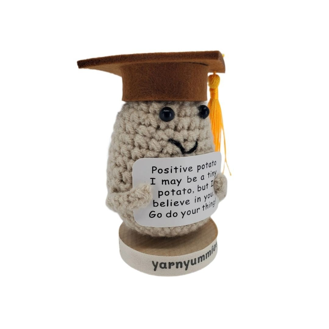 Crocheted potato plush wearing a graduation cap with a quote on a white background