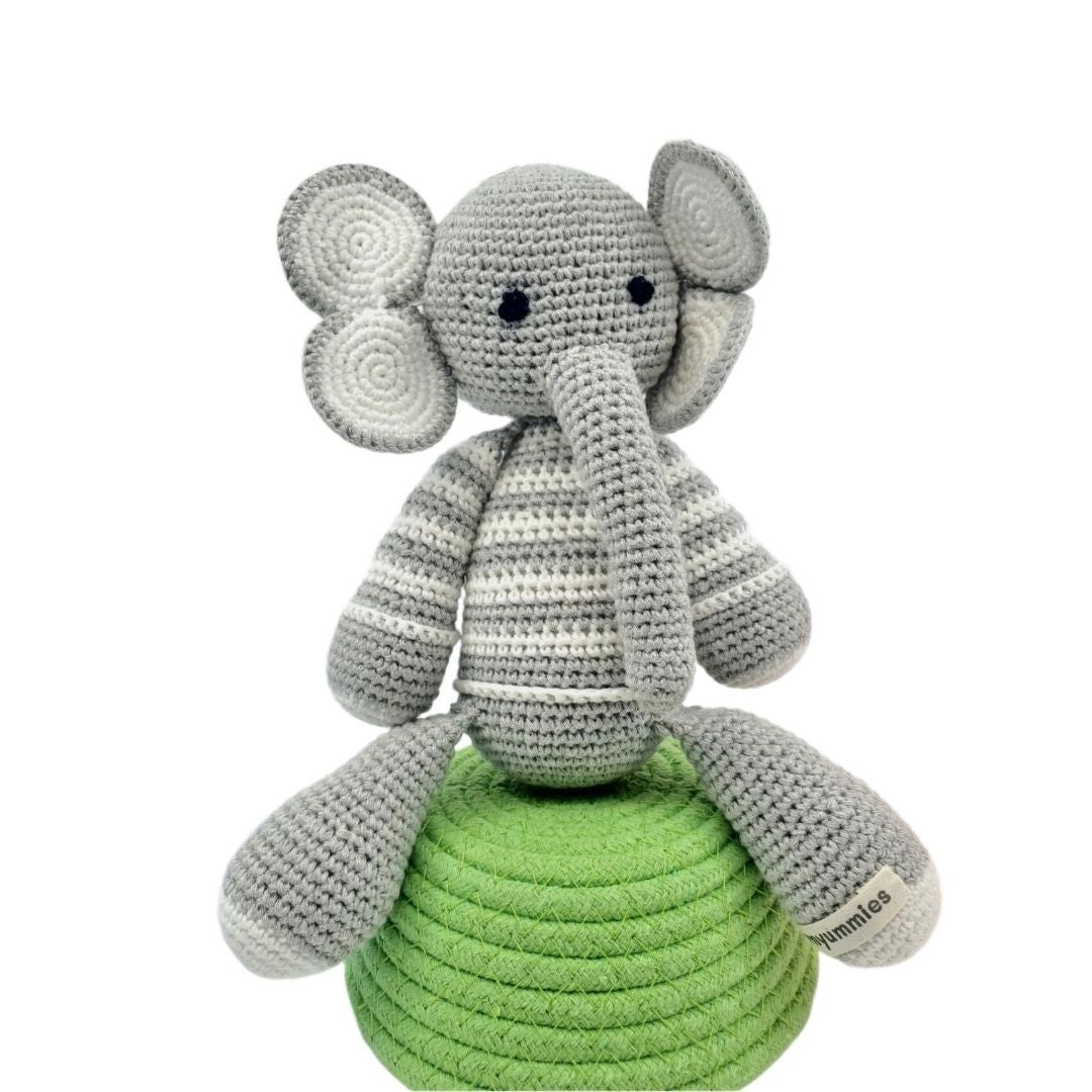 Crocheted elephant toy with a green base on a white background