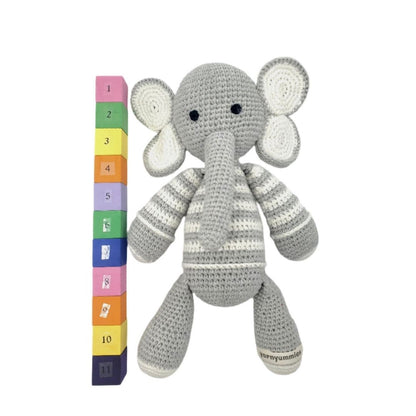 Crocheted elephant toy with a colorful height chart on a white background