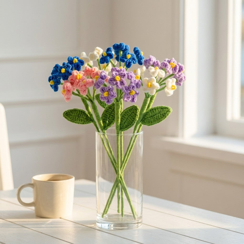 Glass vase with colorful artificial flowers on a light wooden surface.