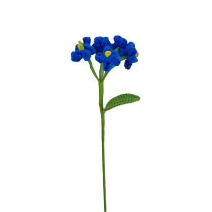 Blue crocheted flower with green stem on a white background
