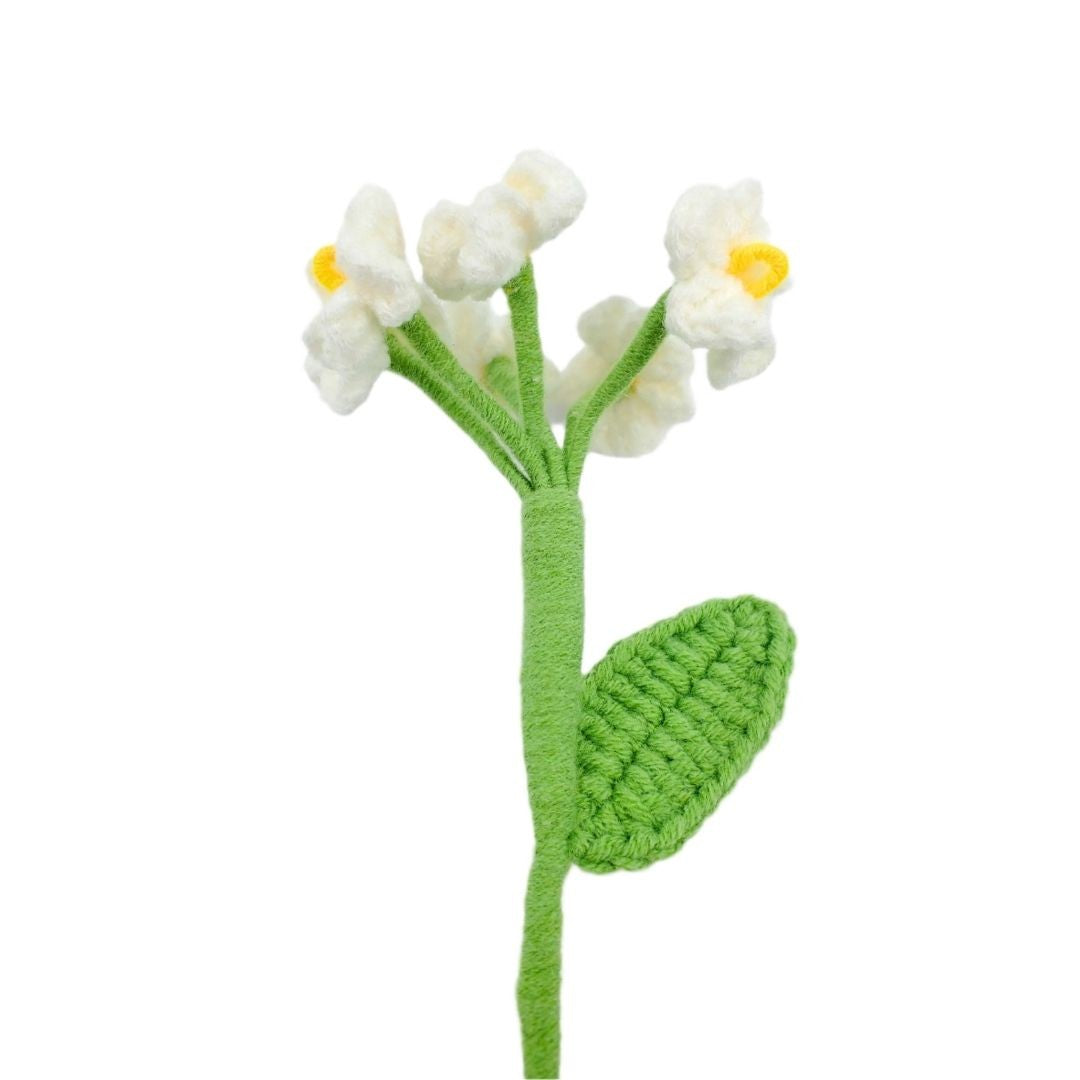 Knitted flower with white petals and green stem on a white background