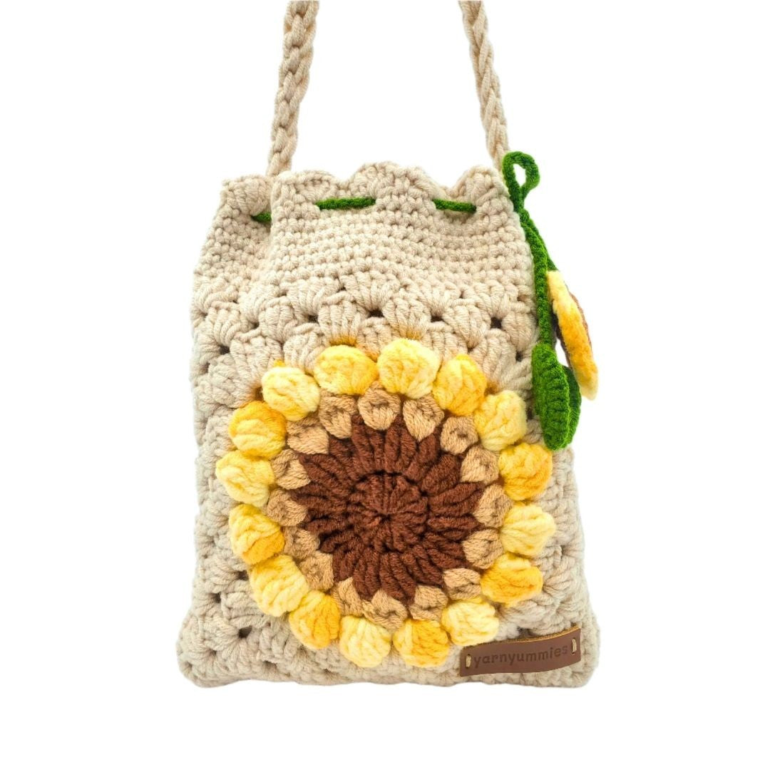 Beige crocheted bag with sunflower design on a white background