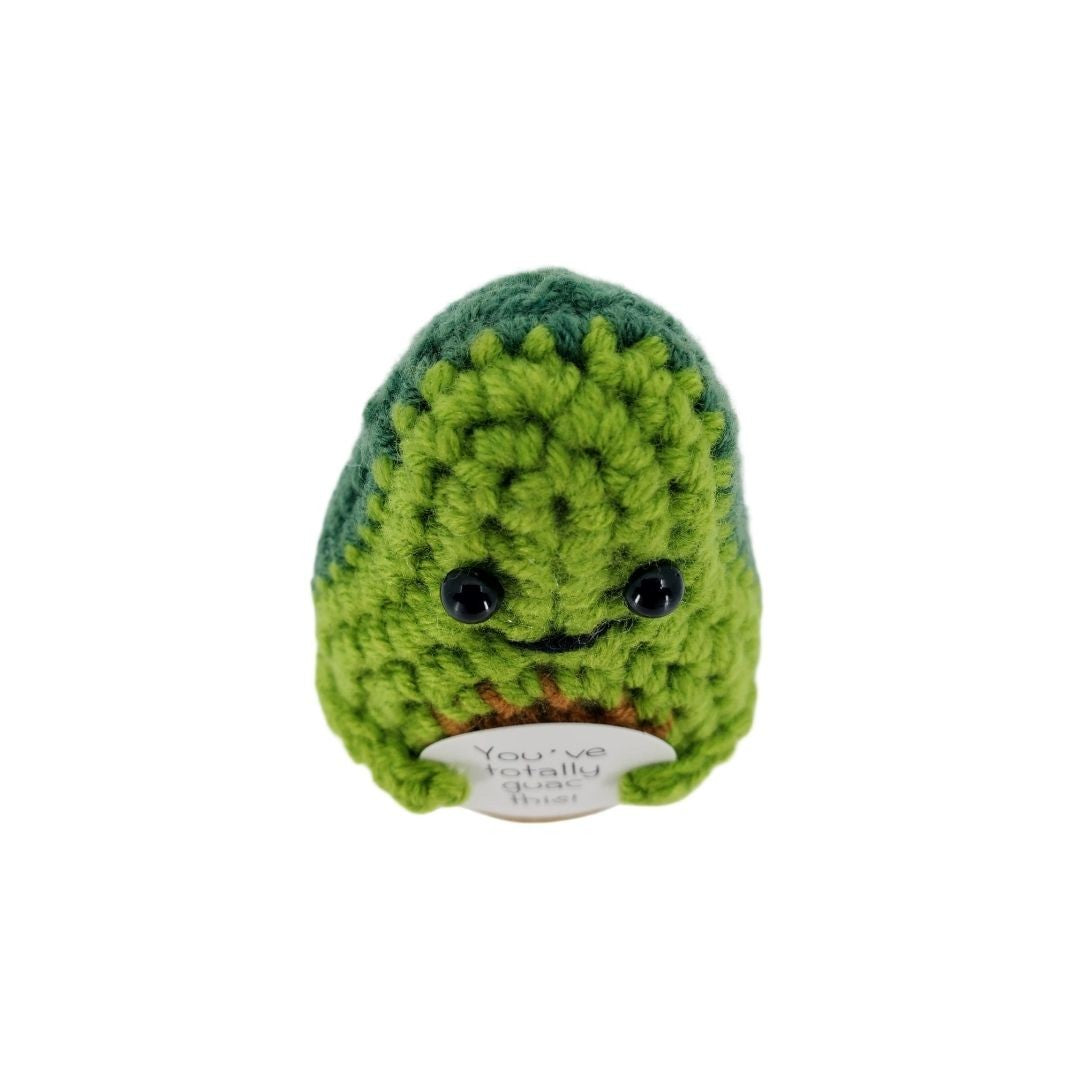 Green crocheted avocado plush decor with a white label on a white background