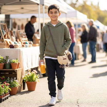 Child walking at an outdoor market with a drink and crocheted lamb designed crossbody bag