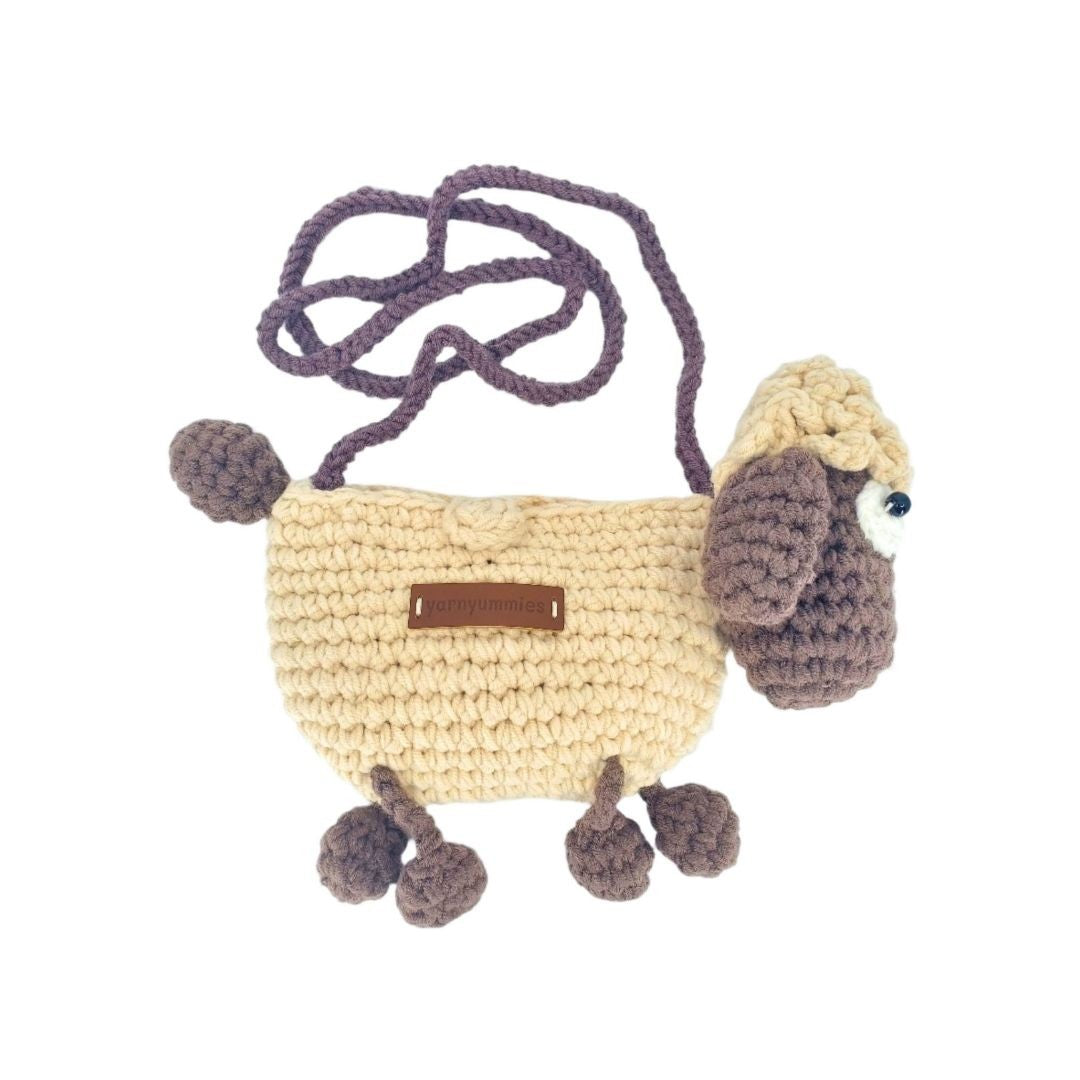 Crocheted lamb-shaped bag with a strap on a white background