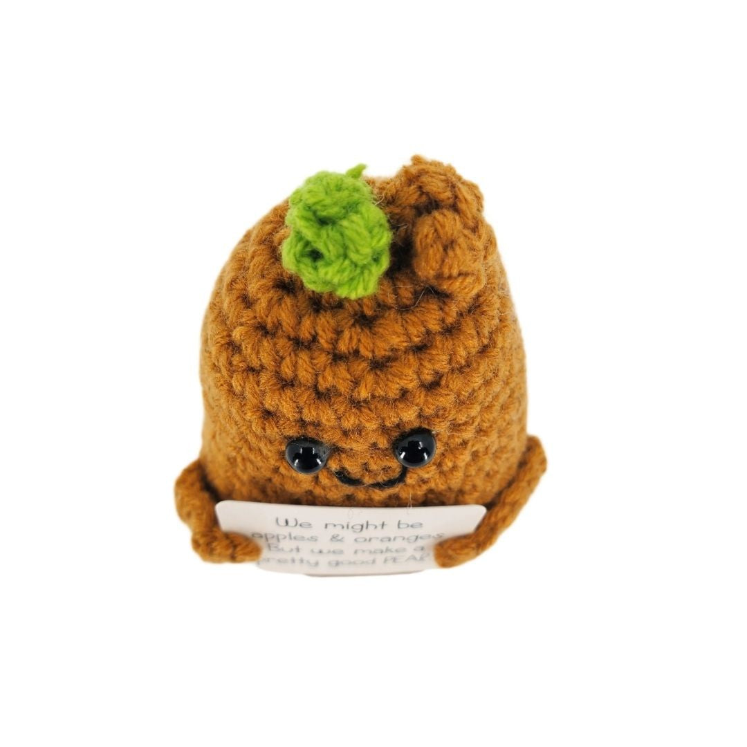 Crocheted pear character with a smiling face on a white background