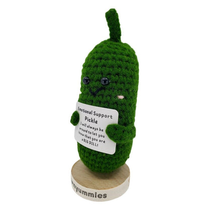 Green crochet pickle plush with a label on a white background