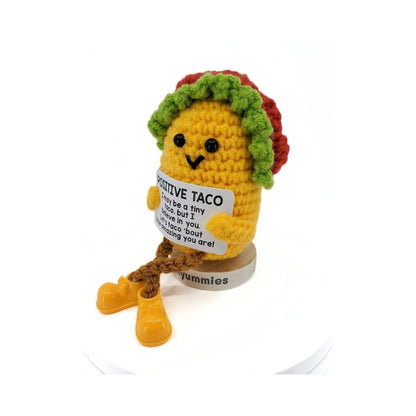 Amigurumi taco plush toy with a message tag on a white background