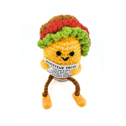 Crocheted toy resembling a taco with a card message on a white background