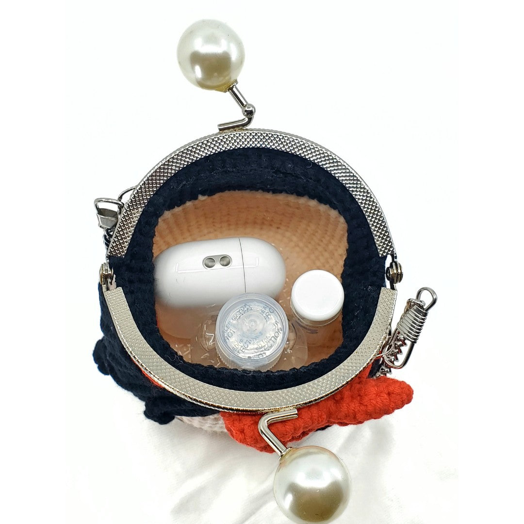 Small round pouch with pearl embellishments containing white earbuds and a small bottle.