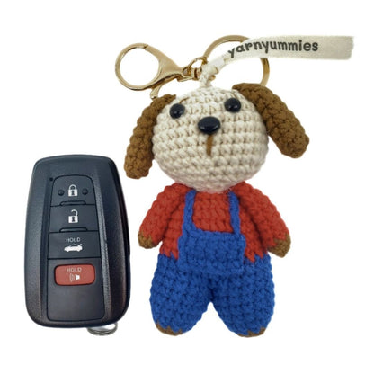 Crocheted dog keychain with a car key fob on a white background, featuring the brand 'yarnyummies'.