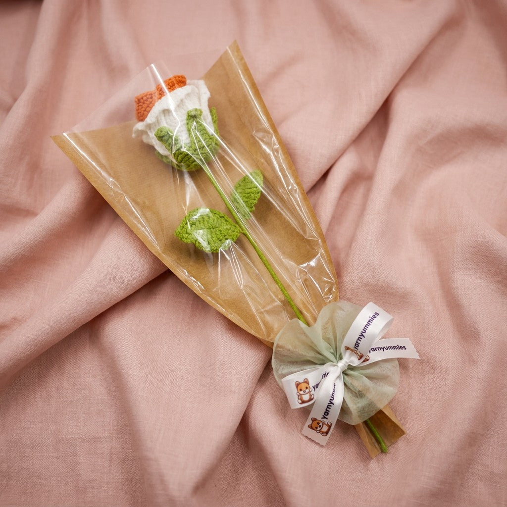 A  crocheted rose flowers in clear plastic on a pink fabric background