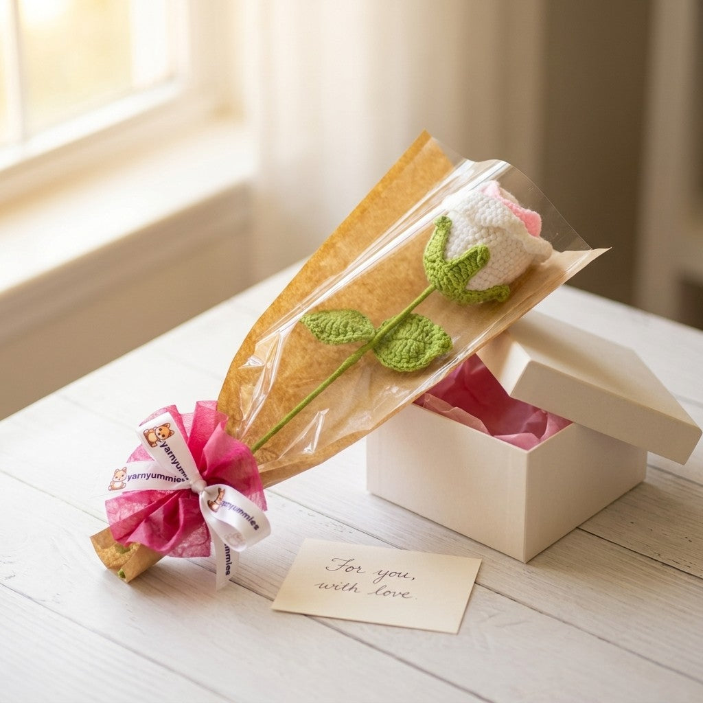 Gift with a crocheted flower and a small card on a wooden surface