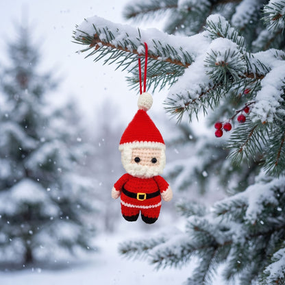 Handmade crochet full body Santa ornament by YarnYummies hanging from a snow-covered evergreen branch in a snowy outdoor setting.