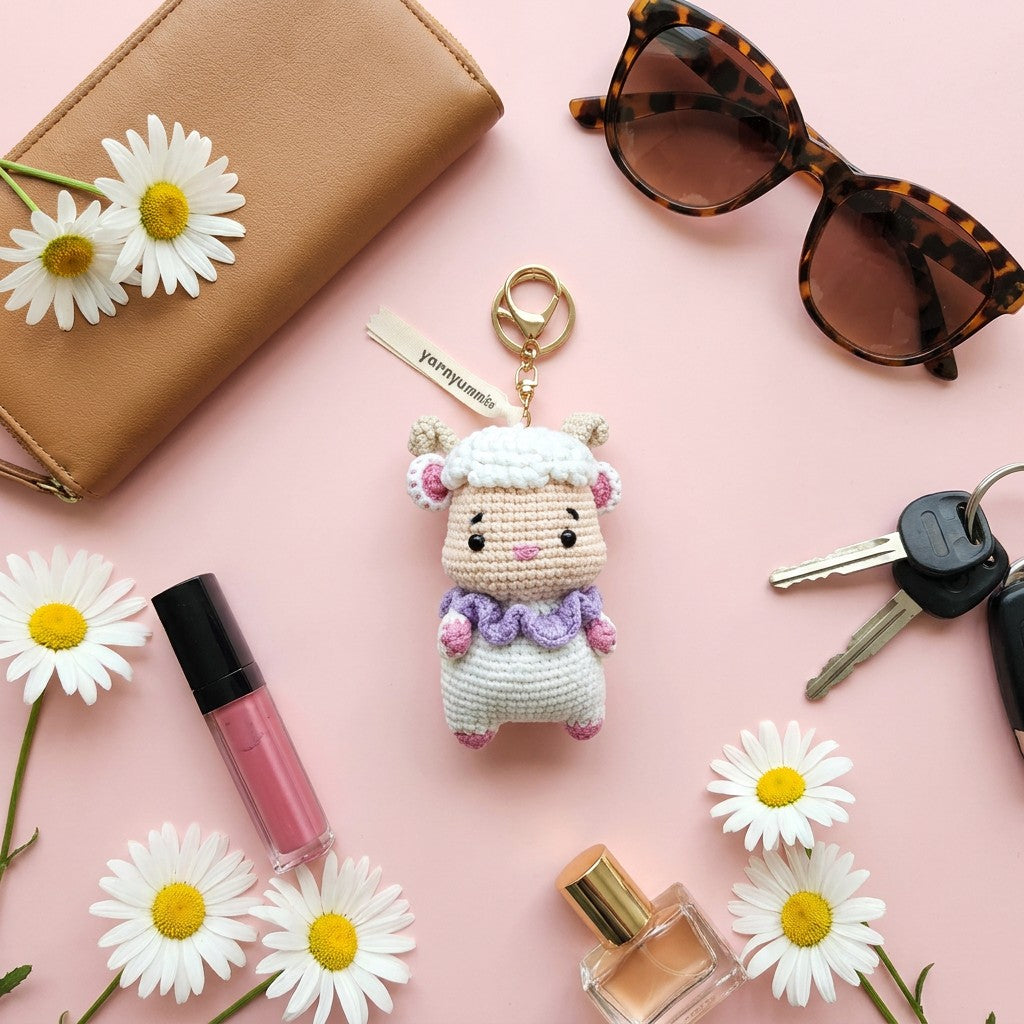 Keychain with a cute design on a pink background with flowers, lip gloss, and sunglasses.