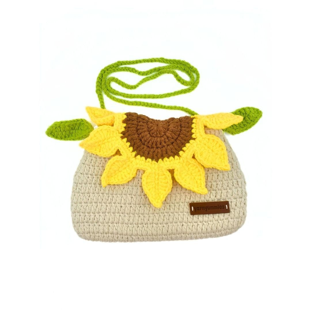 Crocheted sunflower purse with a green strap on a white background