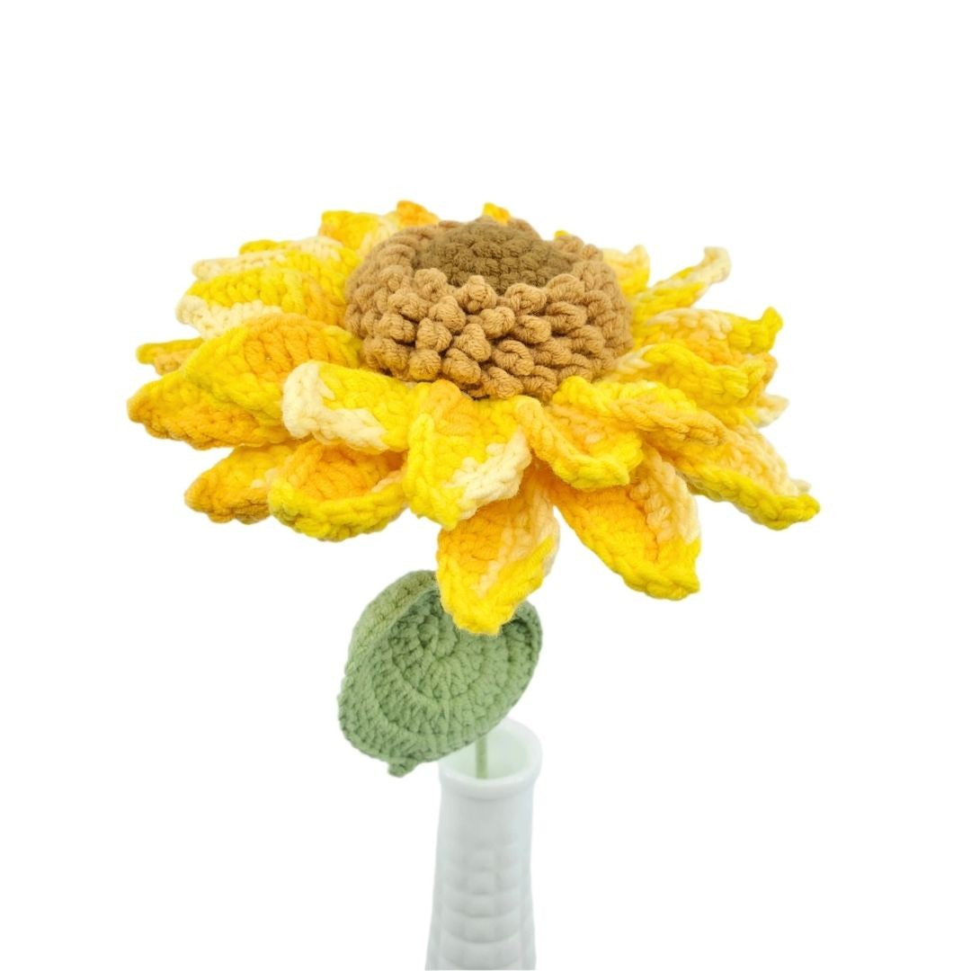 Crocheted sunflower with a white vase on a white background