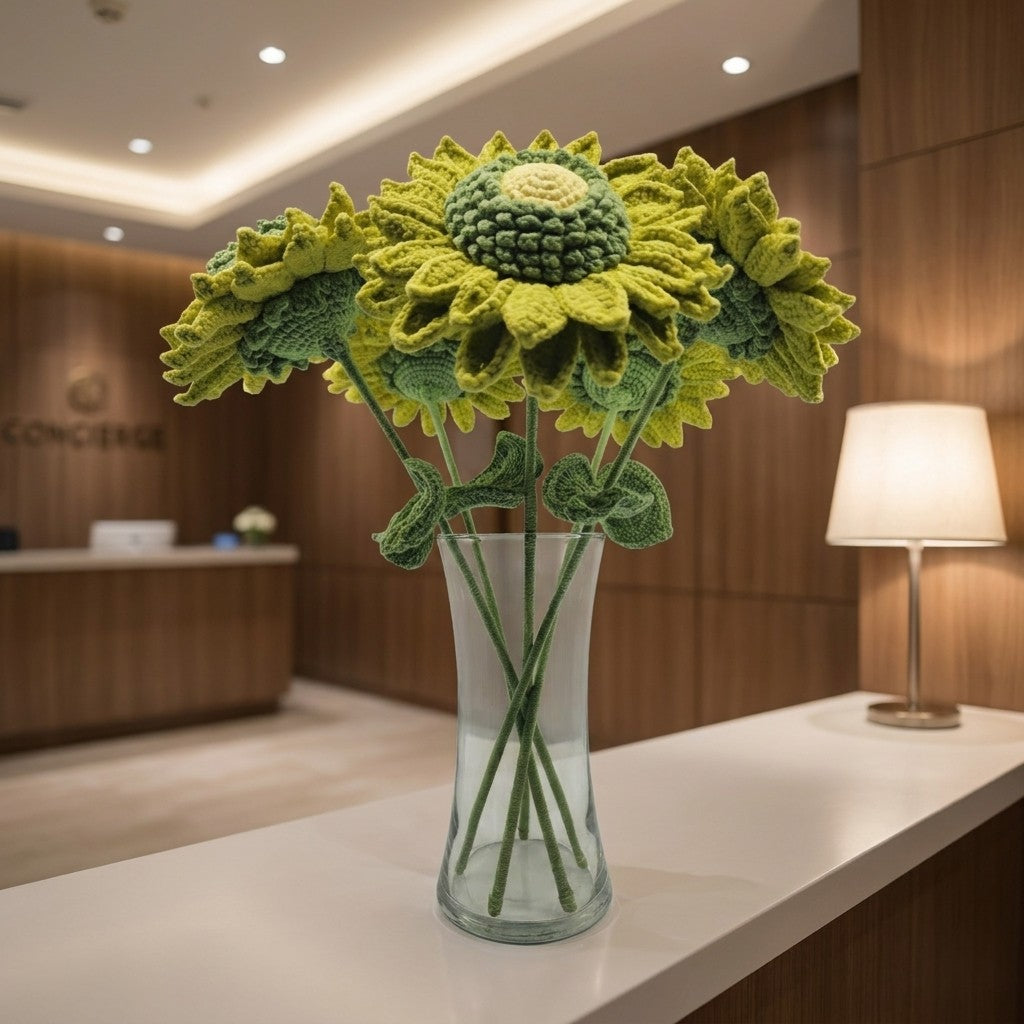 Crocheted sunflowers in a glass vase on a table in an indoor setting
