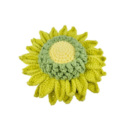 Crocheted sunflower with green leaves on a white background