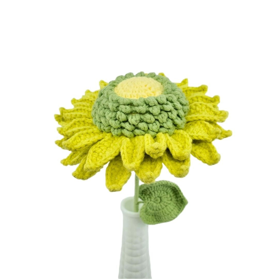Crocheted sunflower with a white vase on a white background