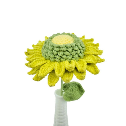Crocheted sunflower with a white vase on a white background