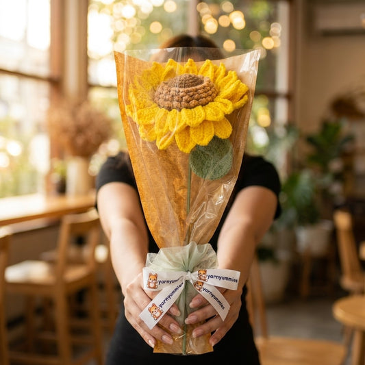 Person holding a bouquet of sunflowers in a blurred indoor setting