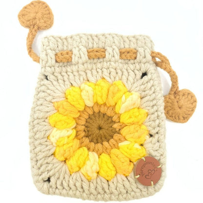 Crocheted pouch with sunflower design and brown accents on a white background