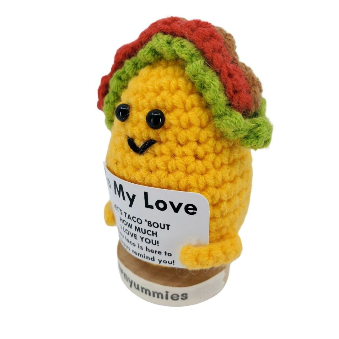 Crocheted taco plush toy with a label on a white background