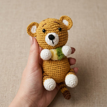 Hand holding a small tiger with a beige background
