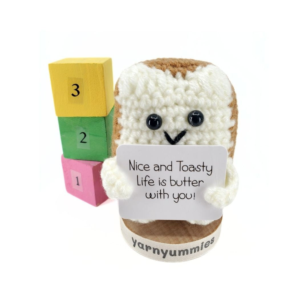 Crocheted plush resembling a slice of bread with a face, colorful blocks, and a 'yarnyummies' tag on a white background.