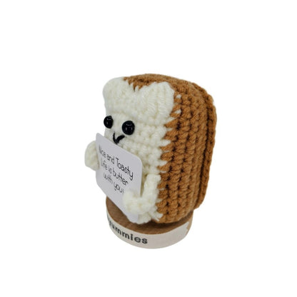 Crocheted bread toast character plush holding a sign with text on a white background